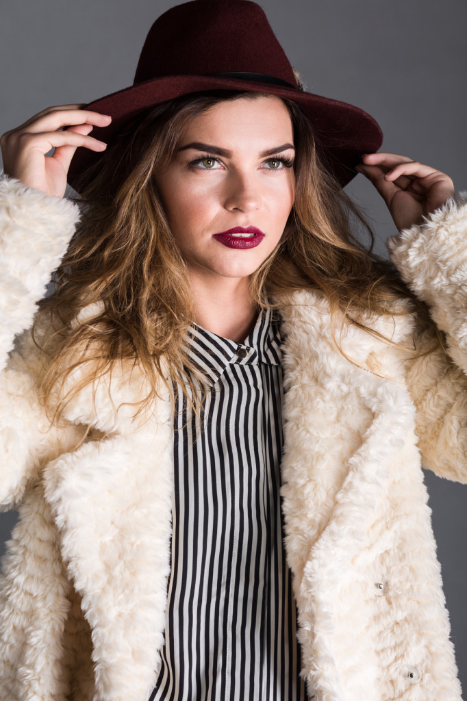 Shot of a young woman trying on a hat