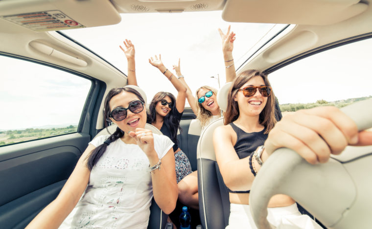 Group of girls having fun with the car